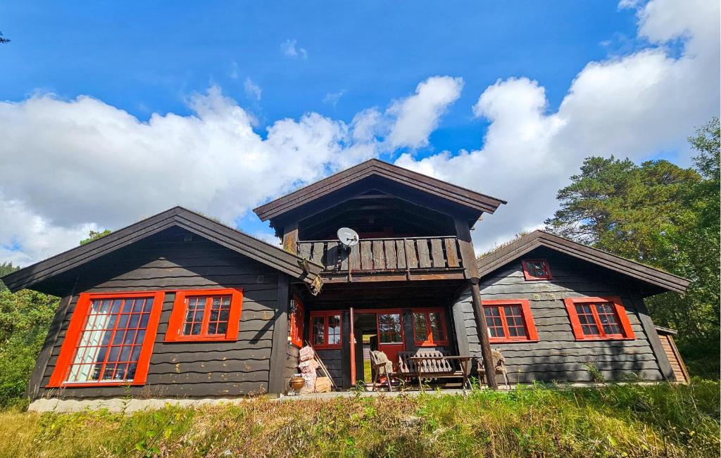 a log cabin with orange windows and a porch at Gorgeous Home In Eggedal With Sauna in Eggedal
