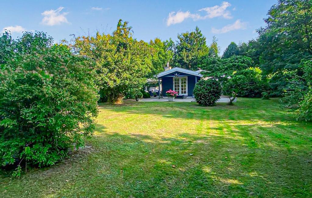 a yard with a blue house in the background at Amazing Home In Hundested With Wifi in Hundested