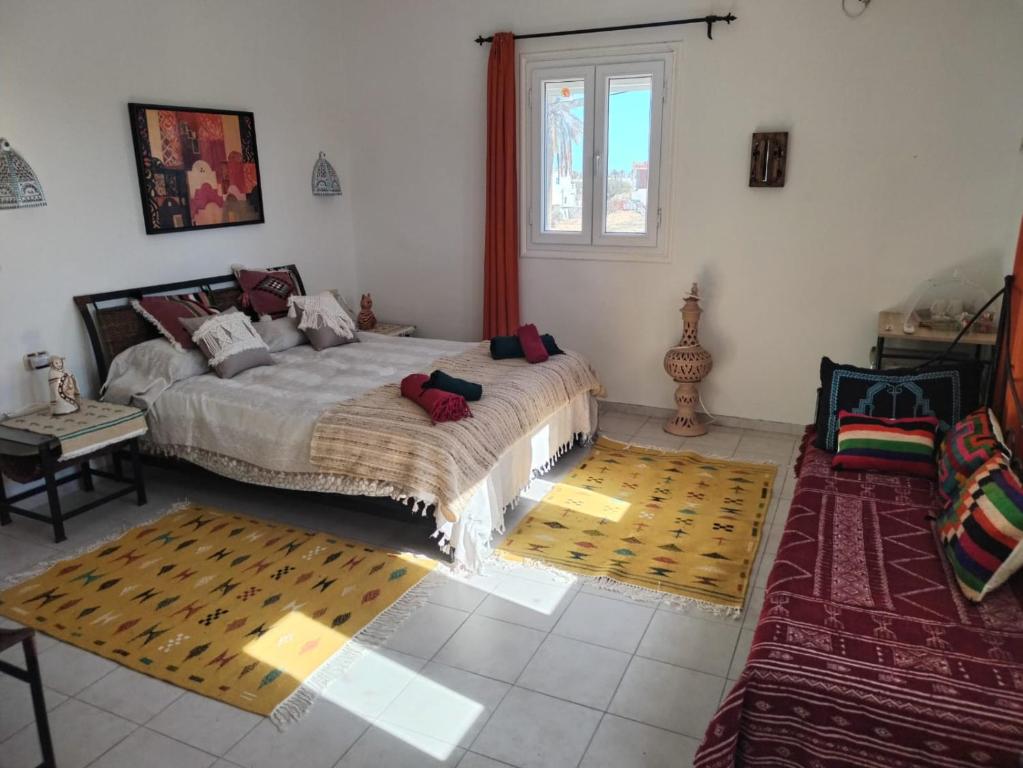 a bedroom with a large bed and a window at Maison Cally in Midoun