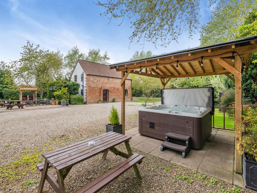 a barbecue under a pavilion with a picnic table at The Hayloft - 17238 in York
