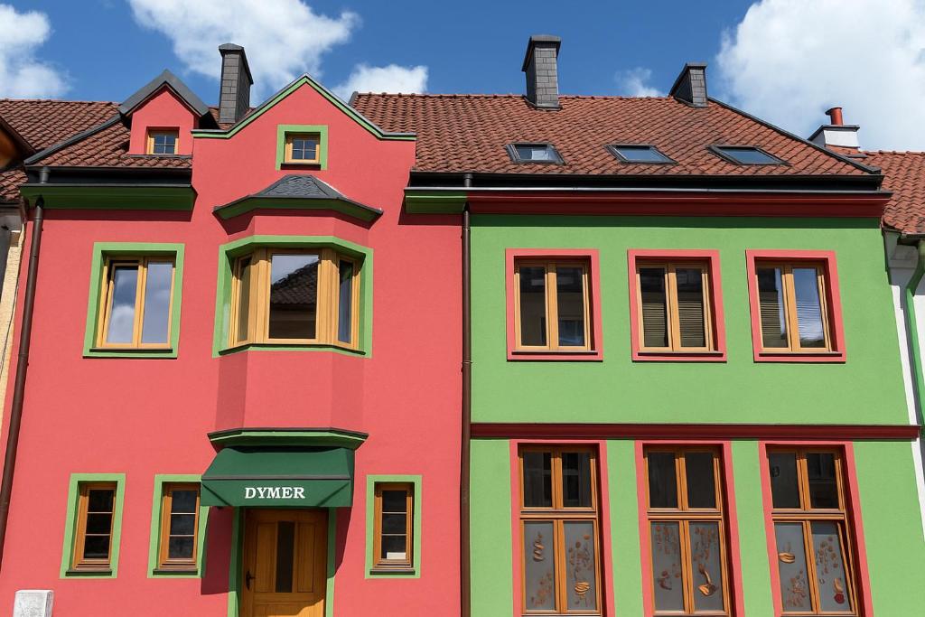 a colorful house with a sign that reads dinner at Dymer in Biskupiec