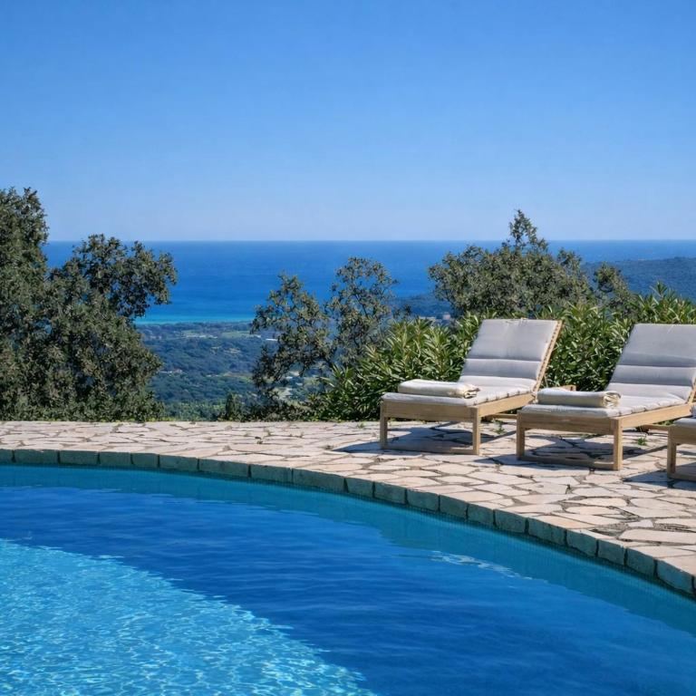 a swimming pool with two lounge chairs next to it at Villa le repaire in Ramatuelle