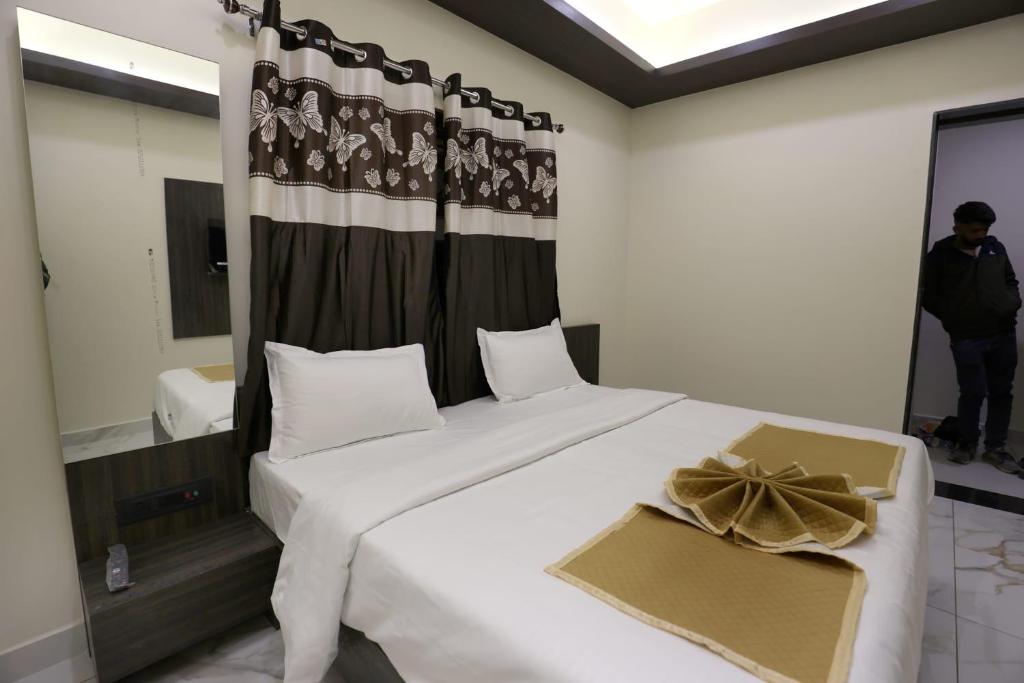 a bedroom with a large white bed and a flag at Hotel Bansi Palace in Dwarka