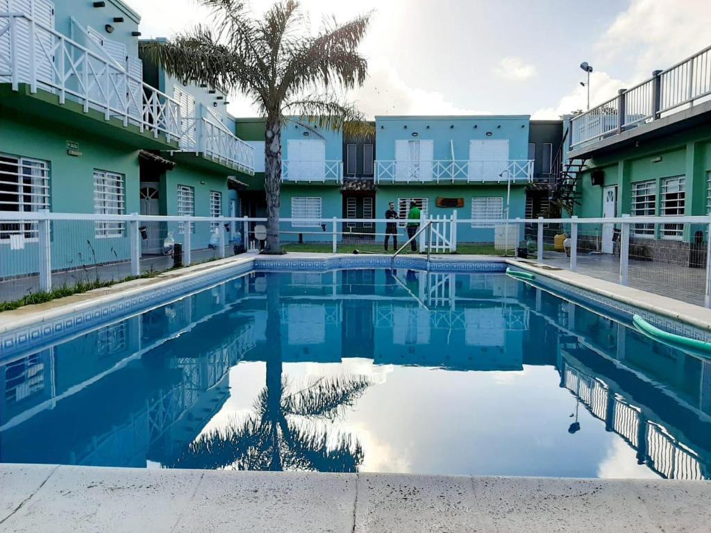 a swimming pool in front of a building at Complejo Hueney in Mar de Ajó