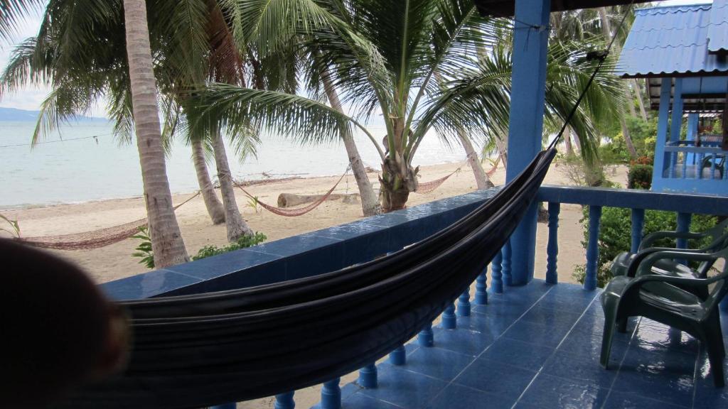 a hammock on a balcony overlooking the beach at Bang Nam Kem Resort in Ban Tai