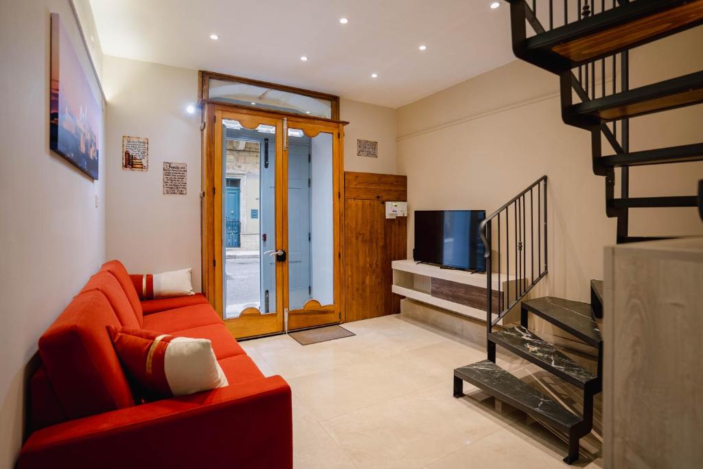 a living room with a red couch and a television at 9 Studio Flat in Victoria