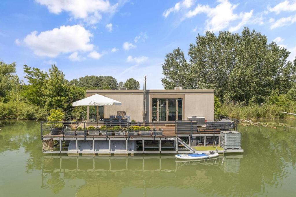 a house on a dock on a body of water at THE ROOT your charming floating home in Bratislava