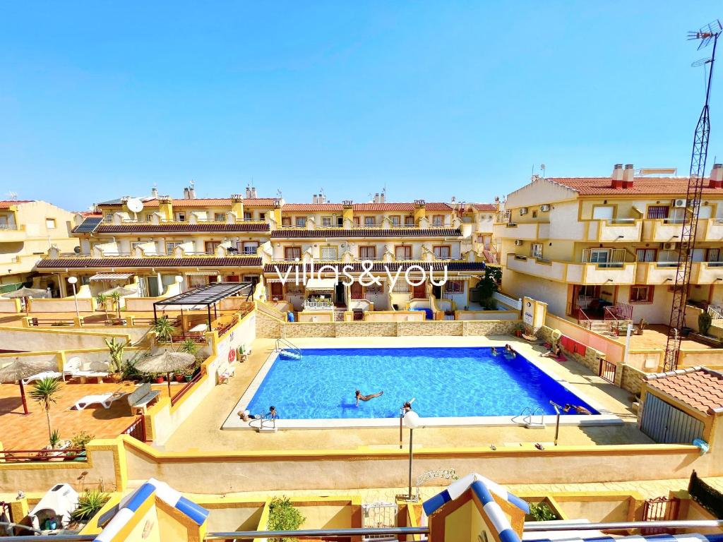 a large swimming pool in front of some buildings at Amapolas by Villas&You in Orihuela Costa