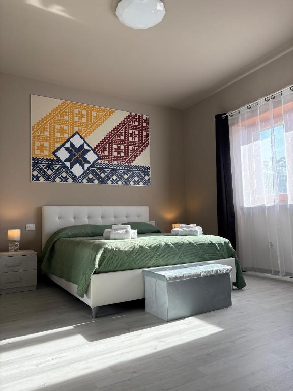 a bedroom with a bed and a painting on the wall at Dimora Alta in Olbia
