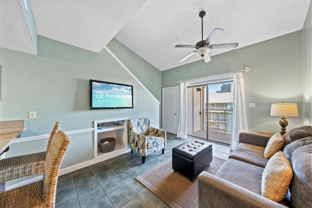 a living room with a couch and a tv at Sugar Beach 313 in Gulf Shores