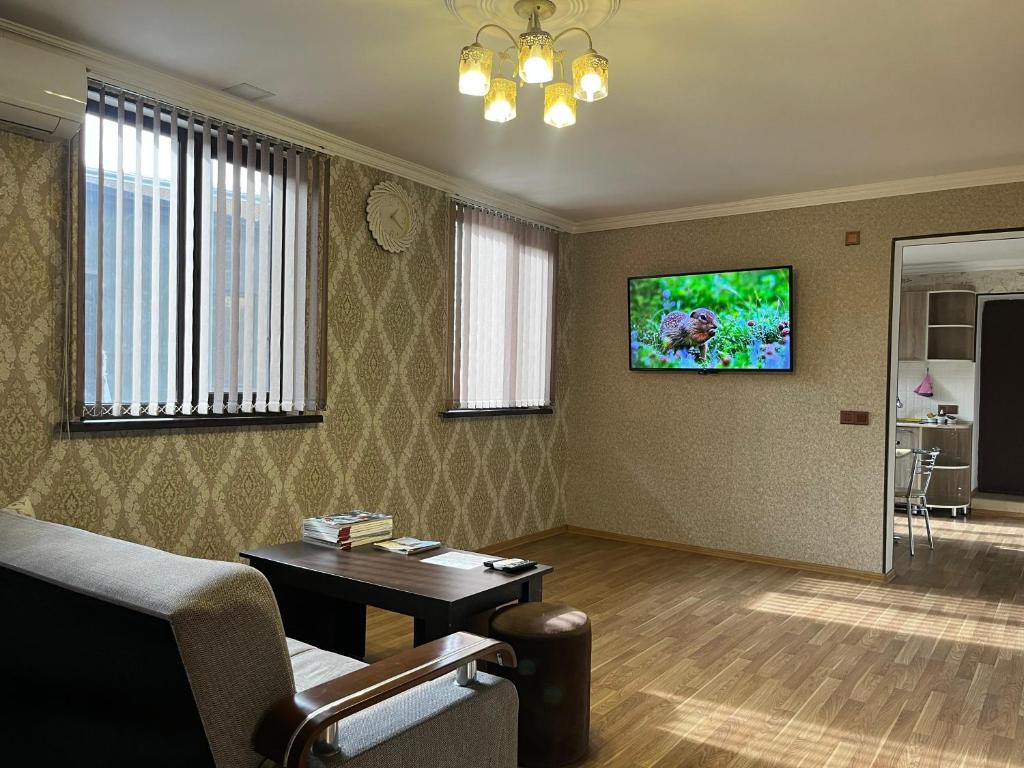 Una sala de estar con un sofá y un televisor en la pared. en Ganja Apartment, en Ganja