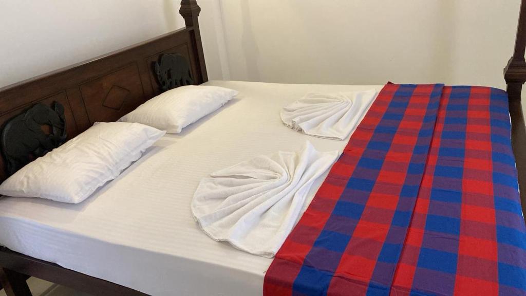 two beds with white sheets and a blue and red blanket at Liya Villa in Ahangama