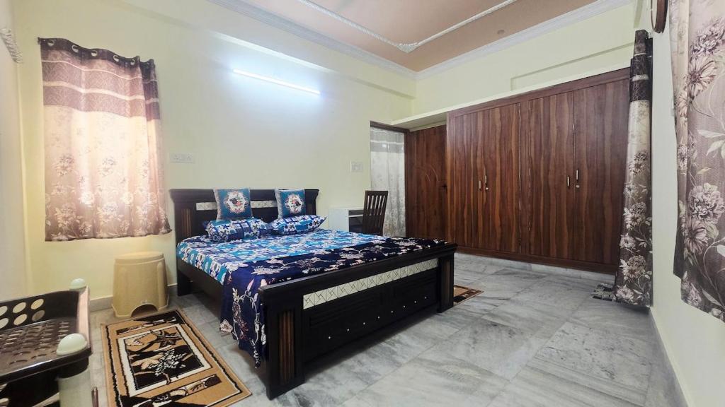 a bedroom with a bed with a blue comforter at Crystal Mansion in Hyderabad