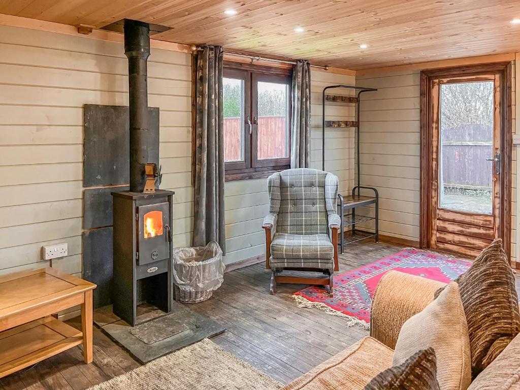a living room with a wood stove and a couch at The Lodge - Uk50721 in Aldbrough
