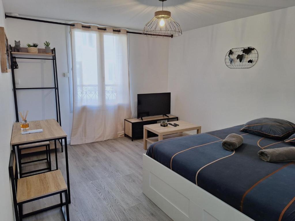 a bedroom with a bed and a tv and a table at Faubourg des voyageurs 4 - Studio climatisé 2 personnes - proche axe autoroute in Saran