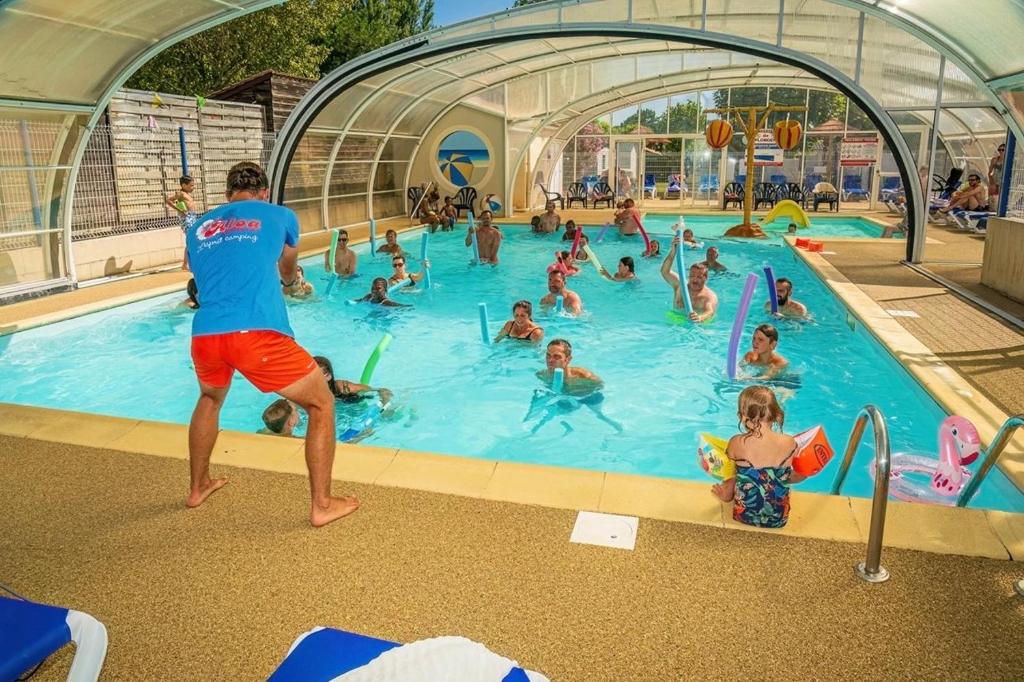 a group of people in a swimming pool at ZEcamping 4 étoiles animé piscine couverte club enfant mini golf dog friendly in La Faute-sur-Mer