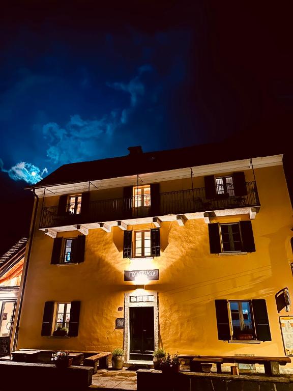 a yellow building with black windows and a door at MyVerzasca Boutique Hotel in Brione