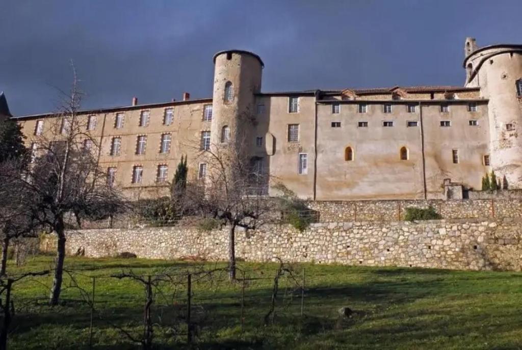 a large castle with a stone wall and trees at Appartement 3 étoiles - eecfga in Saint-Lizier