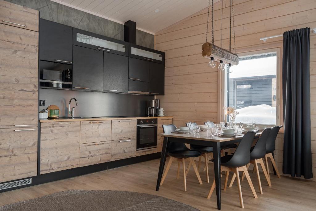 a kitchen with a dining room table with chairs at Louhi B in Äkäslompolo
