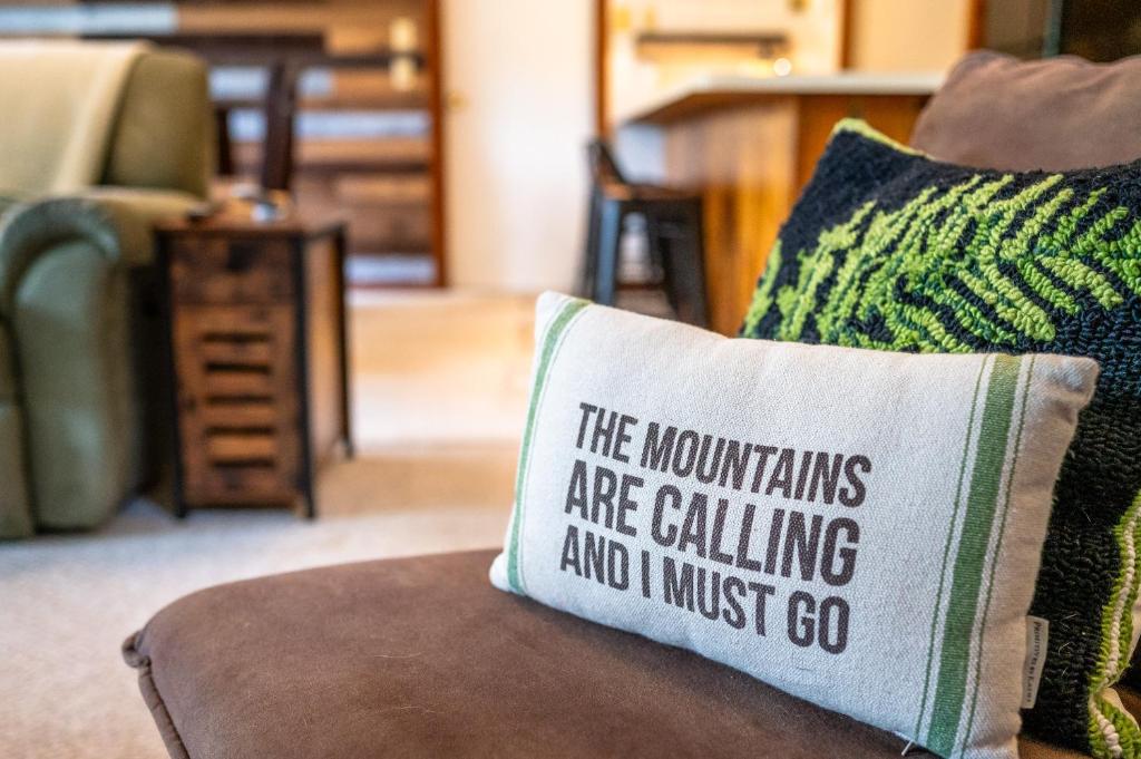 a pillow that says the mountains are calling and i must go at On River Time Bring Your Pup Pool in Bartlett
