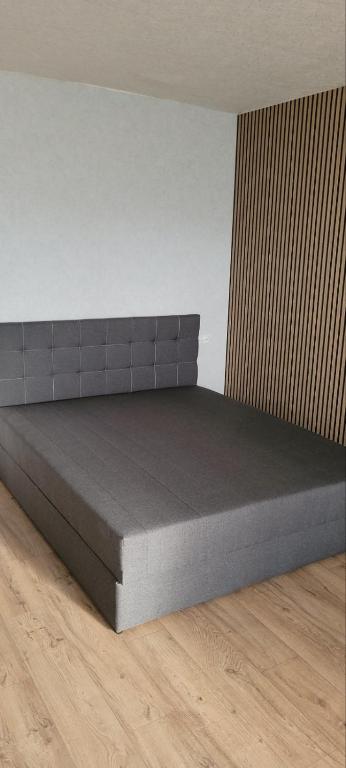 a bed in a room with a wooden floor at 12 Квартал Шинник in Dnipro
