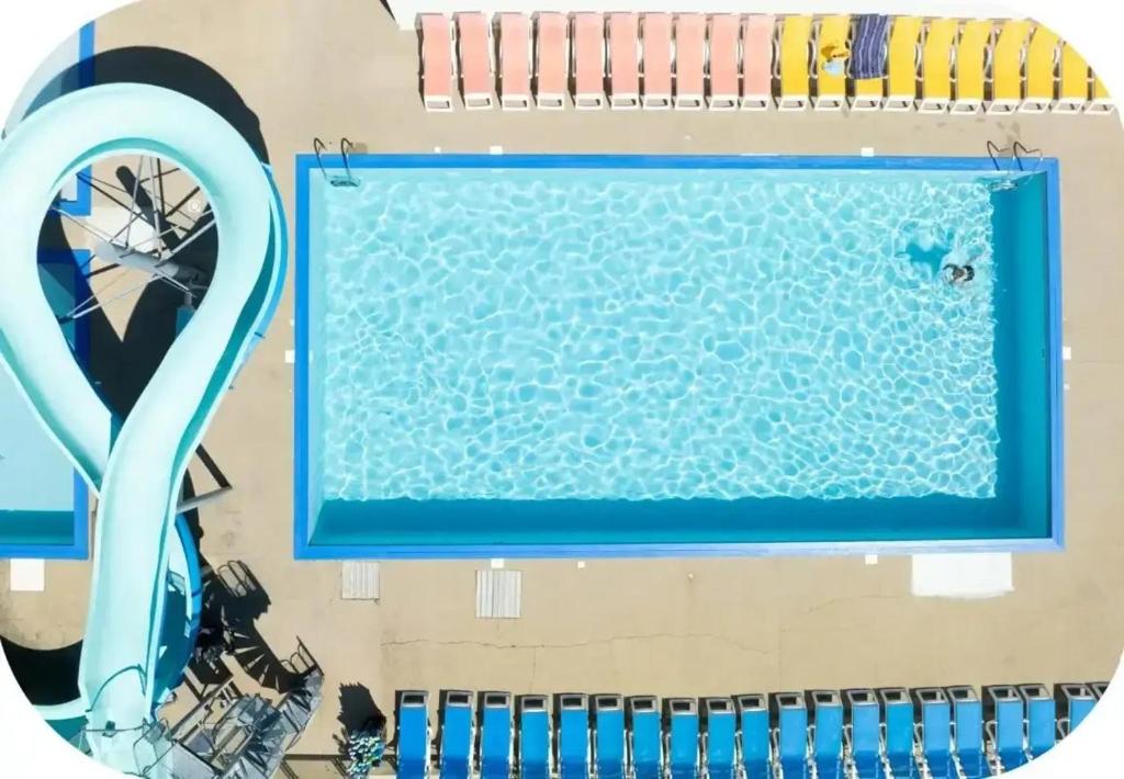 an overhead view of a swimming pool with a blue pool noodle at ZEcamping 4 étoiles familial - parc aqua et soirées animées in Murol