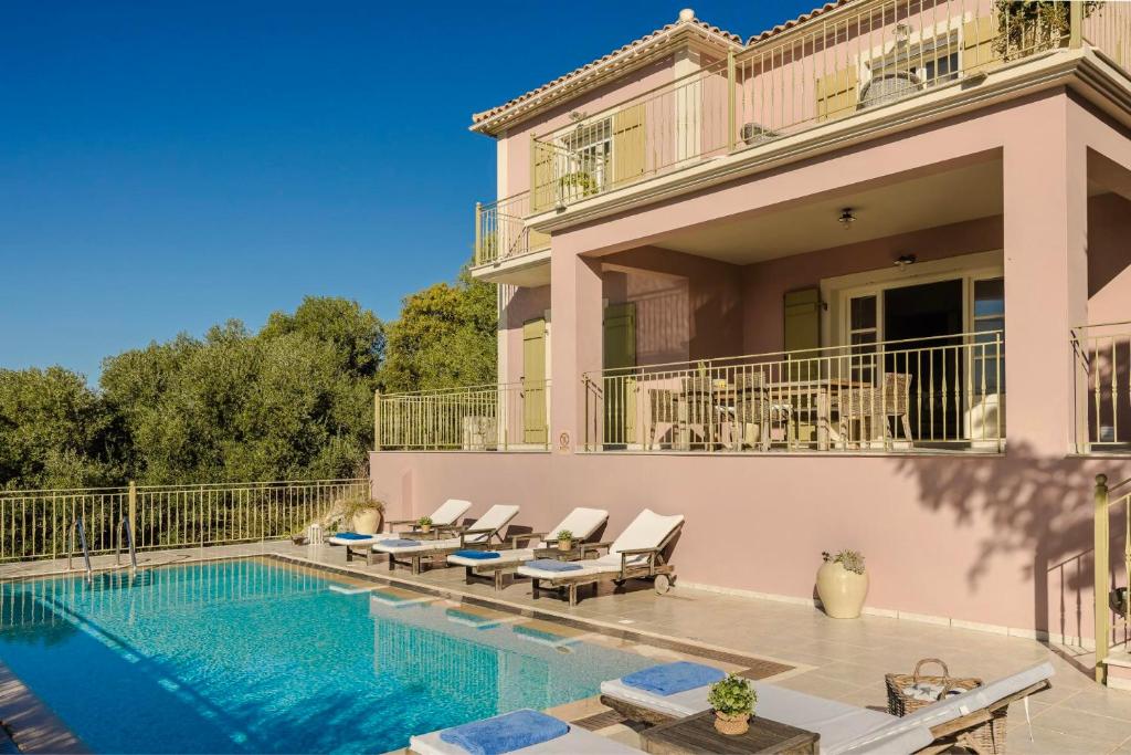 a villa with a swimming pool and a house at Nikolas by Vintage Travel in Fiskardo