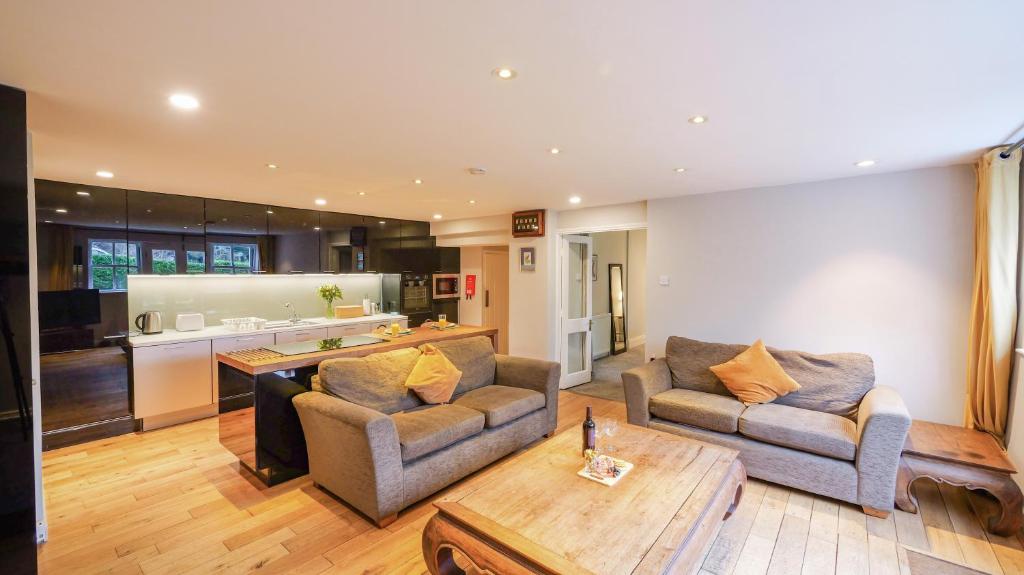 a living room with two couches and a kitchen at Summers Nook in Humshaugh