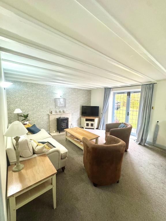 a living room with a couch and a table at Charming 2 bed cottage in Milcote Station