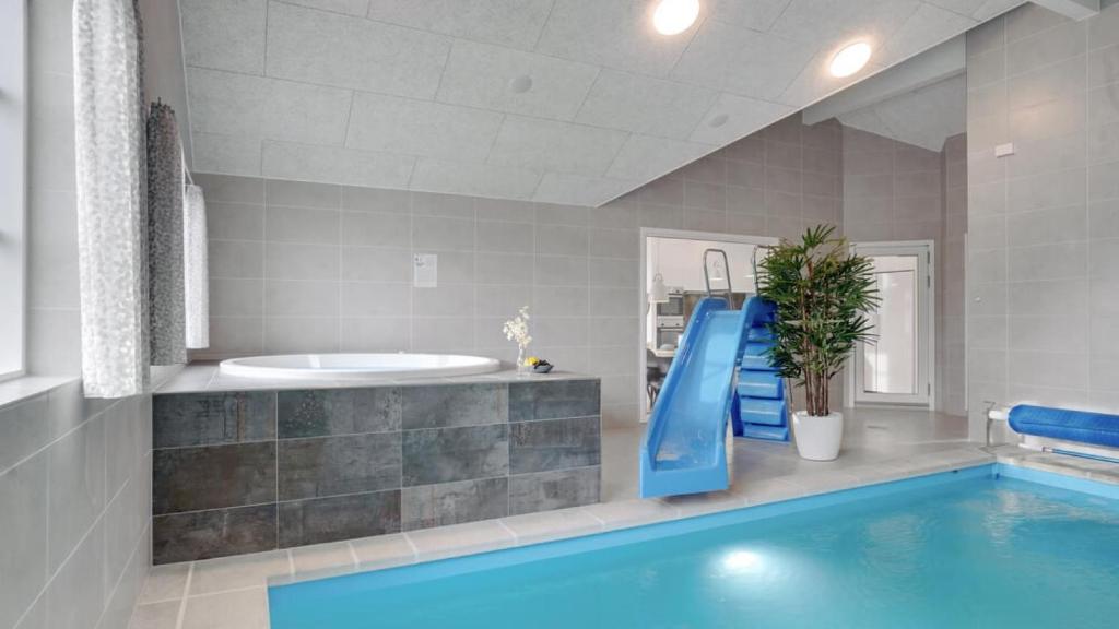 a bathroom with a swimming pool and a tub at Villavilla 520 - Mommark, Sydjylland in Sarup