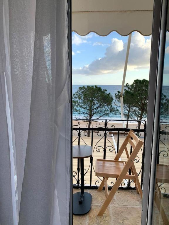 a balcony with a chair and a table and the ocean at Mateo Rooms in Himare