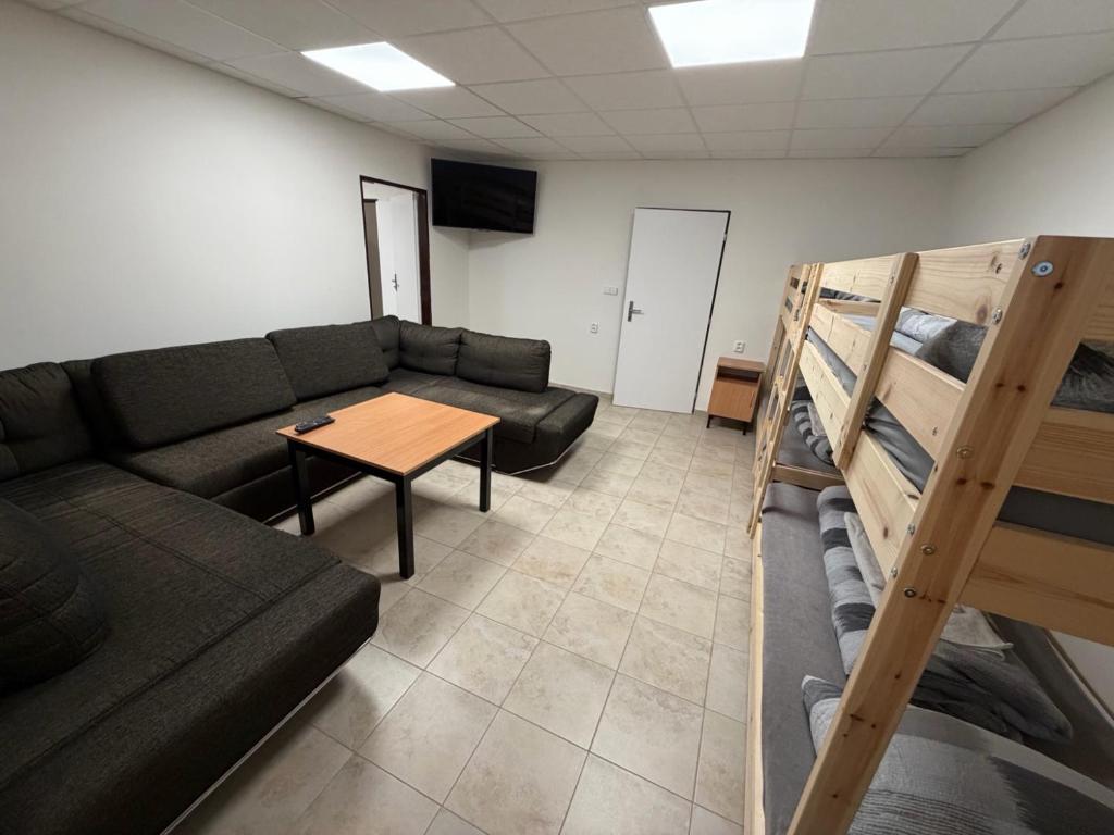 a living room with a couch and a table and bunk beds at Apartmány ProDante in Ostrava