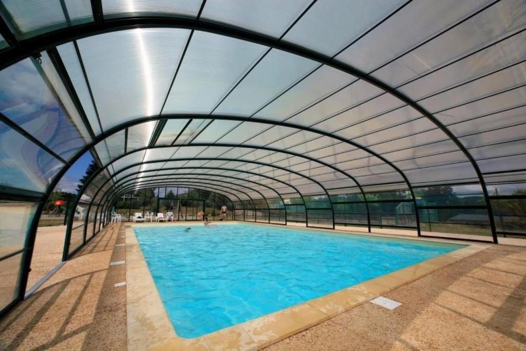 a large swimming pool with an open ceiling at Chalet 3 étoiles - Piscine - eebbhf in Beynat