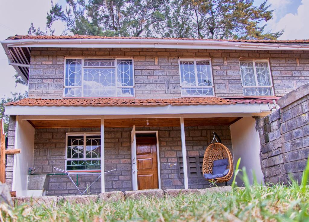 a small brick house with a porch and a swing at The Haven House in Nairobi