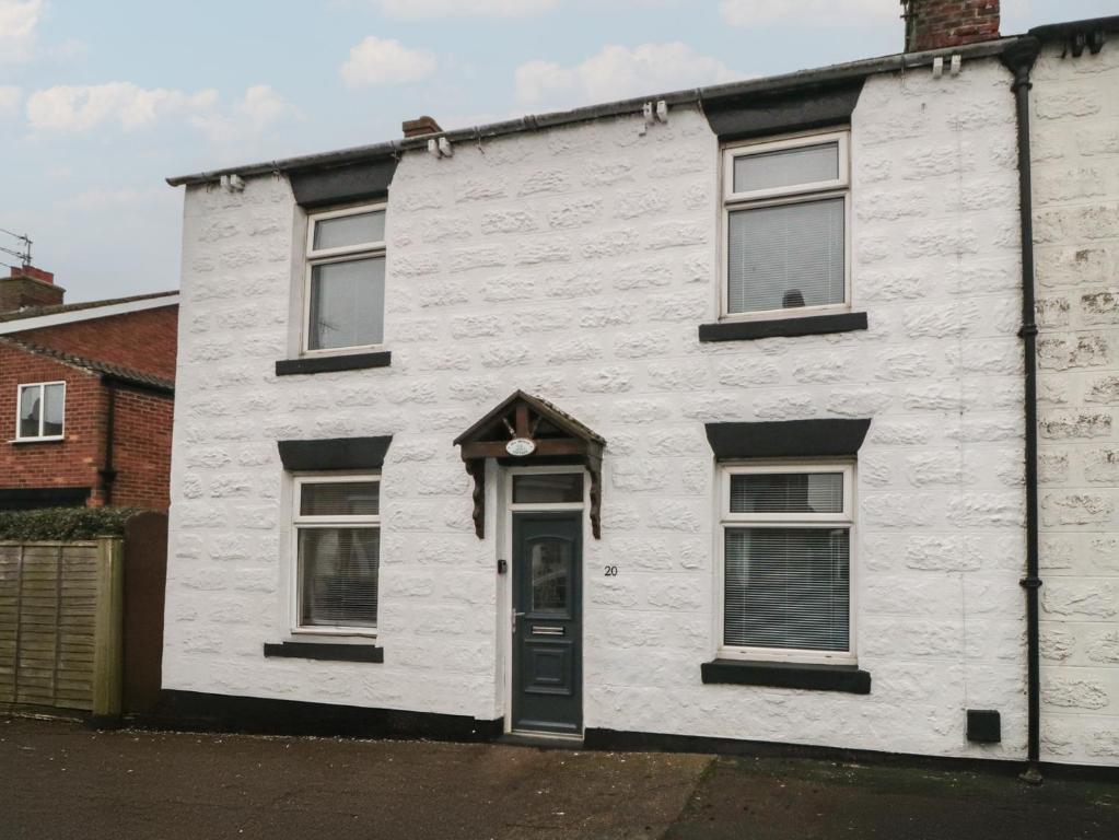 a white house with a black door and windows at Seabreeze in Filey