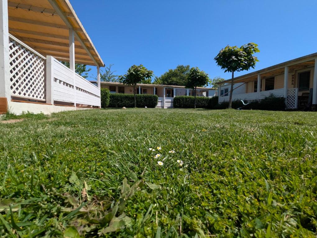 a field of grass next to a building at Къщички Морски Светулки in Sinemorets