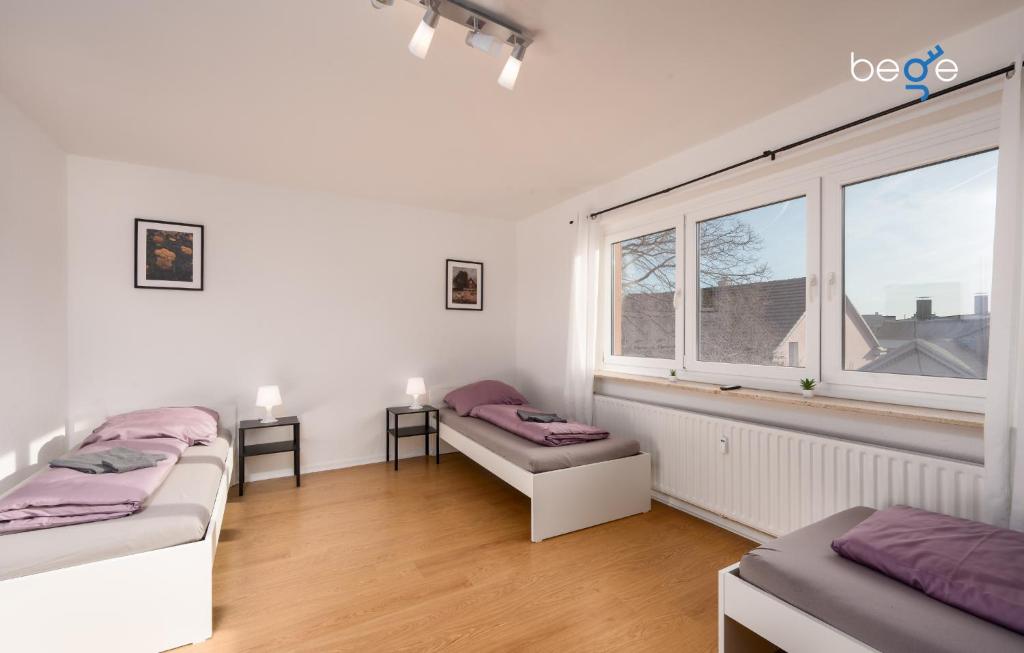 a room with two beds and a window at BEGE APARTMENTS LoftWork in Lüdenscheid