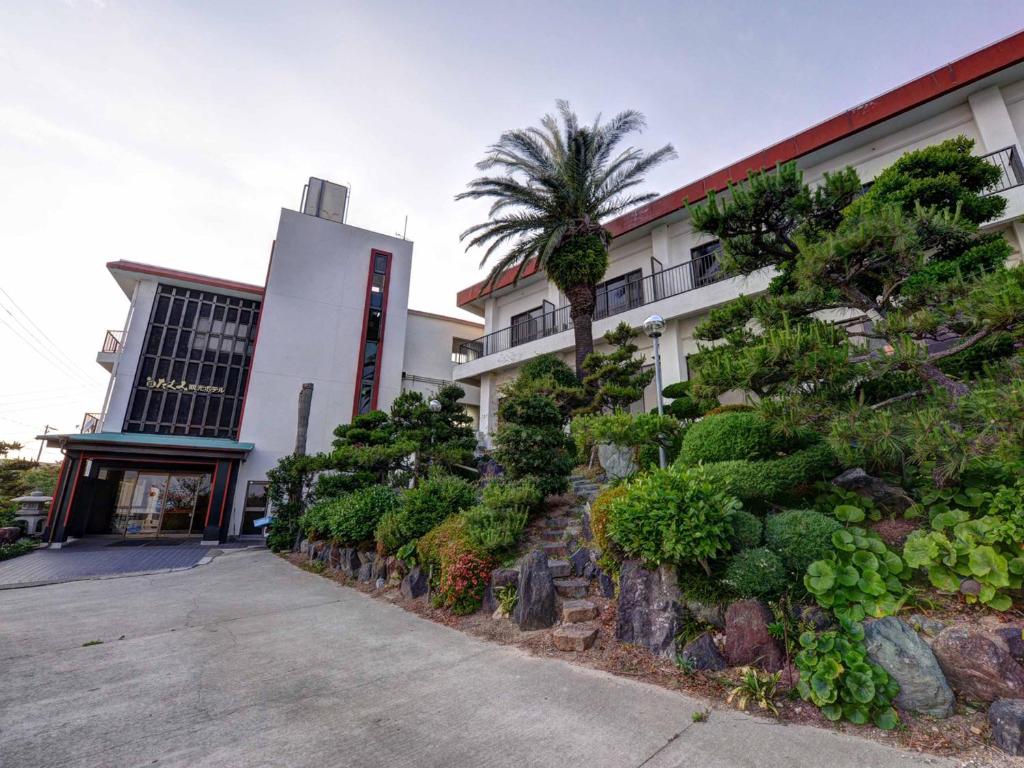 a building with a bunch of plants in front of it at Takumi Kanko Hotel in Minamichita