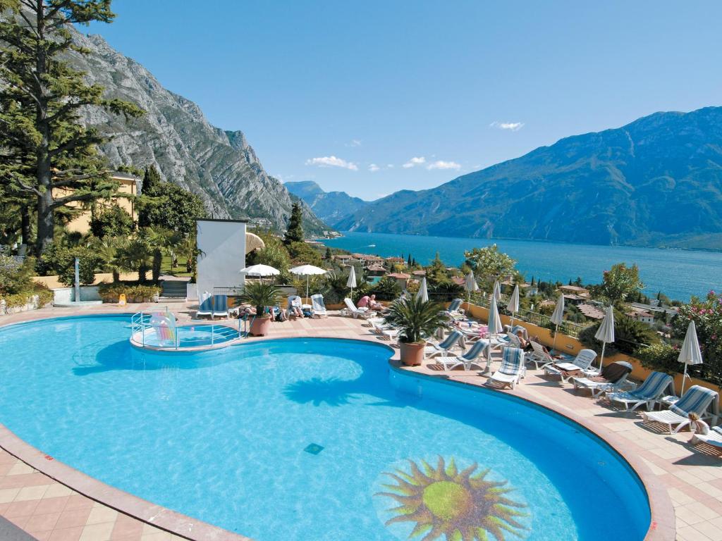 a pool at a resort with a view of the mountains at Hotel San Pietro in Limone sul Garda