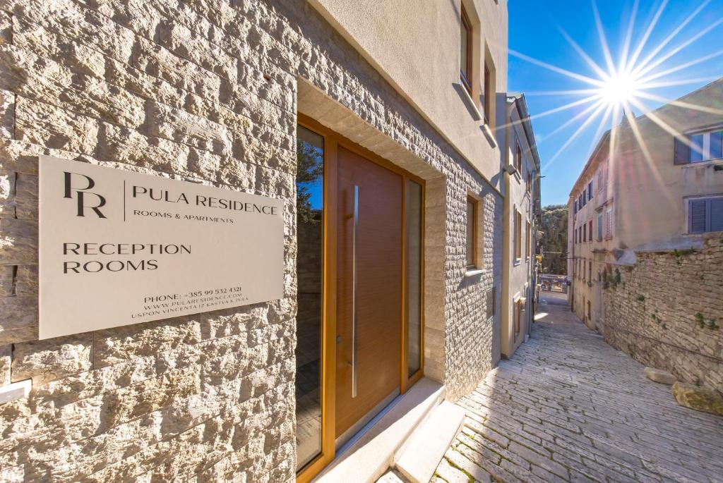 a building with a sign on the side of a street at Pula Residence in Pula