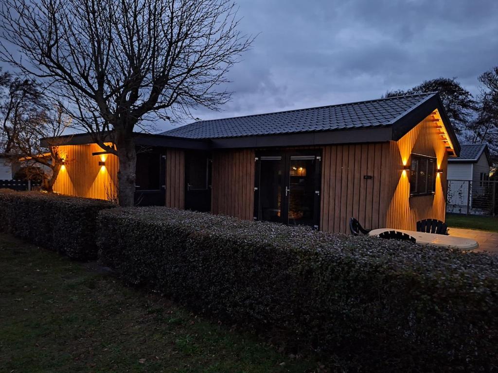 a house with lights on the side of it at Zee aan Geluk in Sint Maartensvlotbrug