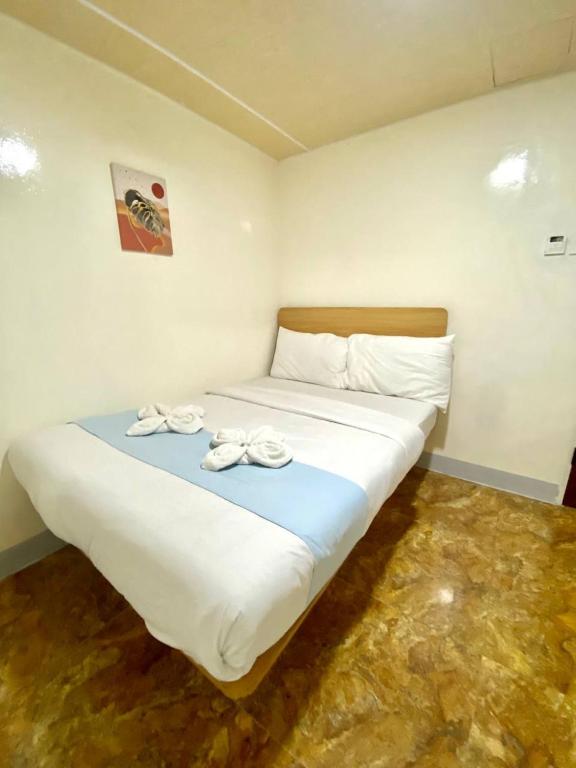 a bedroom with a large bed with towels on it at RedDoorz at Urban Hotel in Zamboanga