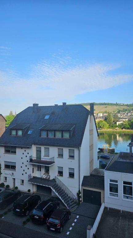 a large white building with cars parked in a parking lot at Ferienwohnungen Bongarden in Bernkastel-Kues