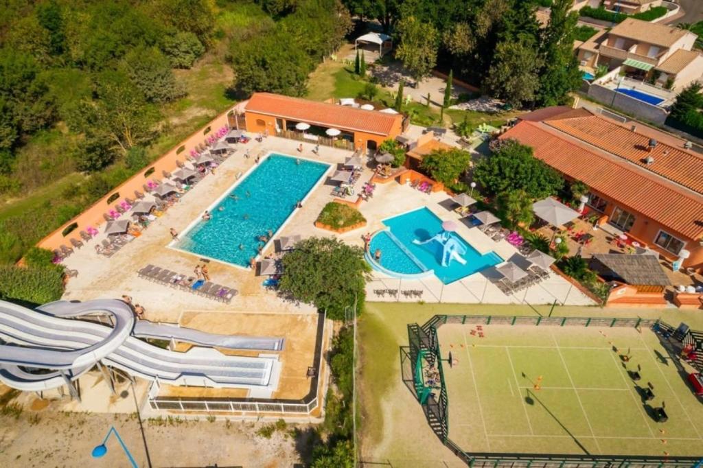 an overhead view of a pool with tables and chairs at ZEcamping 4 familial piscine chauffée club enfant animations au calme in Canet-en-Roussillon