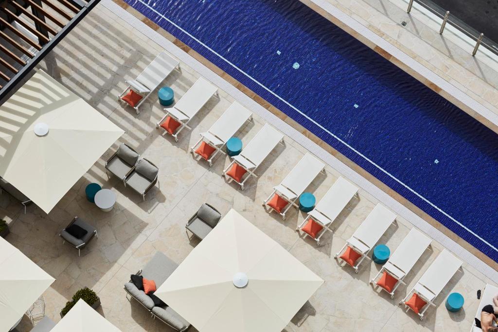 an overhead view of a pool with tables and chairs at Art Series - The Johnson in Brisbane