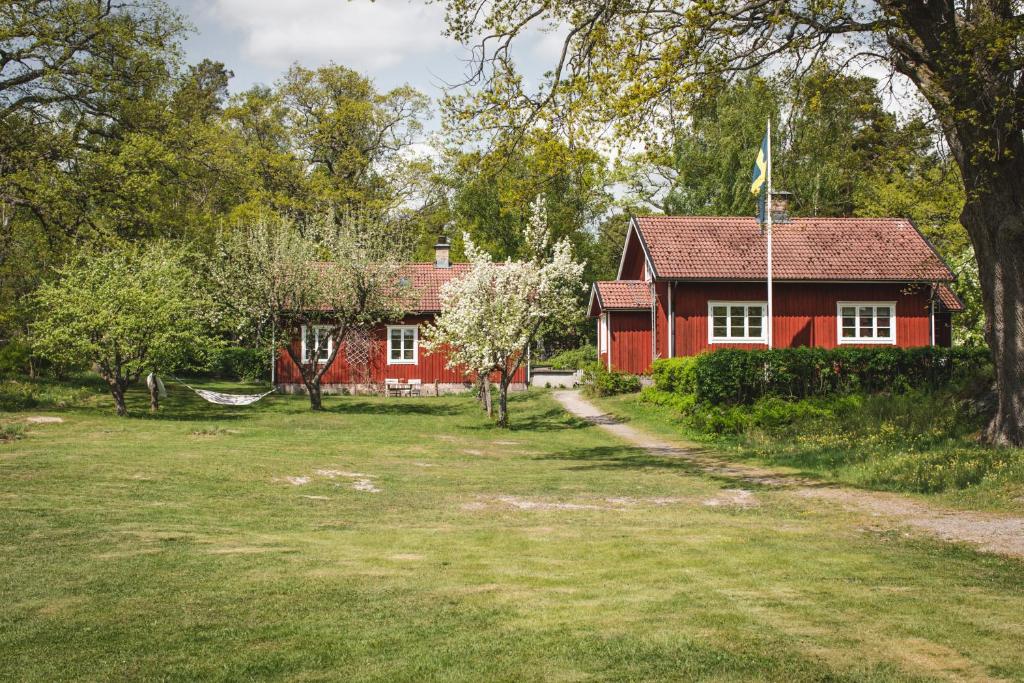 a red house with a yard in front of it at Sävö Vandrarhem & Café in Västerljung