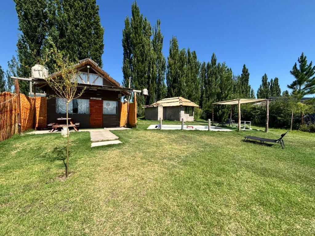 a house with a yard with a bench and a table at Cabanas Embau in San Rafael