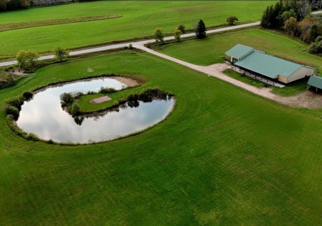 an aerial view of a golf course with a pond at The Alderwood Lodge in Wilson
