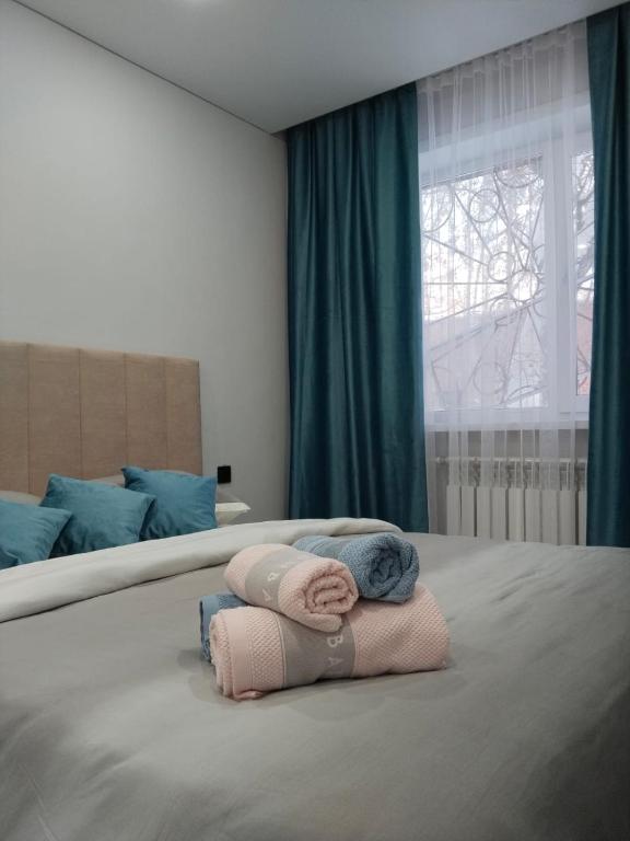 a pile of towels on a bed in a bedroom at Абая in Temirtaū