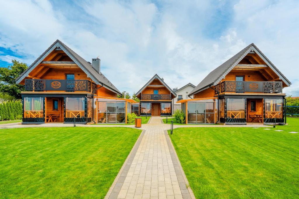 a large house with a green lawn in front of it at Siedlisko Malechowo in Ustronie Morskie